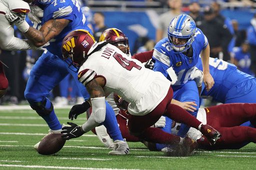 Washington Commanders linebacker Frankie Luvu (4) recovers a Detroit Lions quarterback Jared Goff (16) fumble during the first half of an NFL football divisional playoff game, Saturday, Jan. 18, 2025, in Detroit. (AP Photo/Mike Mulholland)