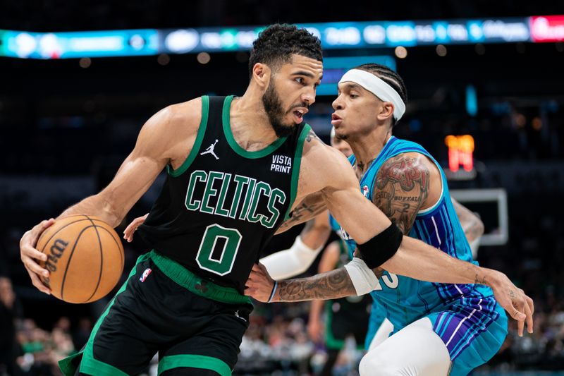 CHARLOTTE, NORTH CAROLINA - APRIL 01: Jayson Tatum #0 of the Boston Celtics drives to the basket while guarded by Tre Mann #23 of the Charlotte Hornets in the third quarter during their game at Spectrum Center on April 01, 2024 in Charlotte, North Carolina. NOTE TO USER: User expressly acknowledges and agrees that, by downloading and or using this photograph, User is consenting to the terms and conditions of the Getty Images License Agreement. (Photo by Jacob Kupferman/Getty Images)