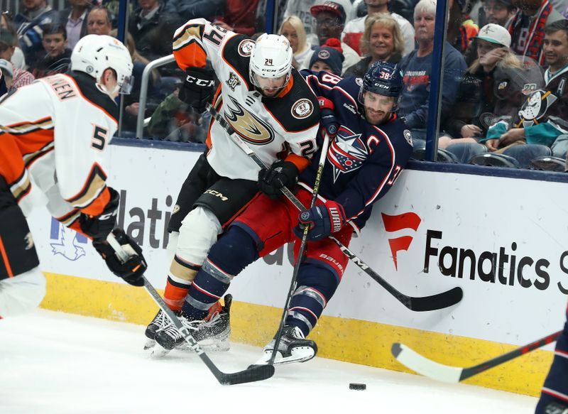 Oct 24, 2023; Columbus, Ohio, USA; Anaheim Ducks center Benoit-Olivier Groulx (24) and Columbus Blue Jackets center Boone Jenner (38) go for the loose puck during the second period at Nationwide Arena. Mandatory Credit: Joseph Maiorana-USA TODAY Sports