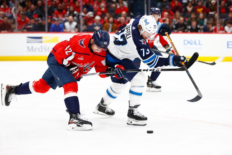 Mar 24, 2024; Washington, District of Columbia, USA; Washington Capitals defenseman Martin Fehervary (42) and Winnipeg Jets right wing Tyler Toffoli (73) battle for the puck during the second period at Capital One Arena. Mandatory Credit: Amber Searls-USA TODAY Sports