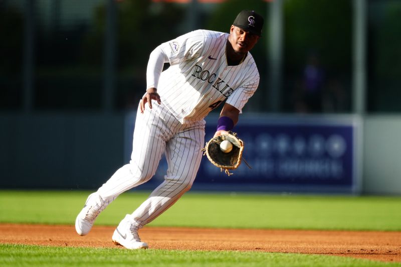 Jun 4, 2024; Denver, Colorado, USA; Colorado Rockies first base Elehuris Montero (44) fields a grounder in the first inning against the Cincinnati Reds at Coors Field. Mandatory Credit: Ron Chenoy-USA TODAY Sports