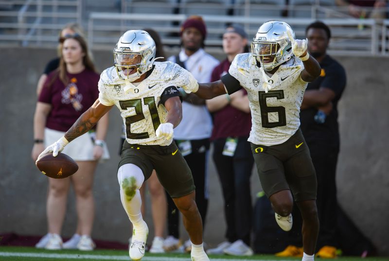 Nov 18, 2023; Tempe, Arizona, USA; Oregon Ducks defensive back Cole Martin (21) celebrates an interception with teammate Jahlil Florence (6) against the Arizona State Sun Devils in the second half at Mountain America Stadium. Mandatory Credit: Mark J. Rebilas-USA TODAY Sports