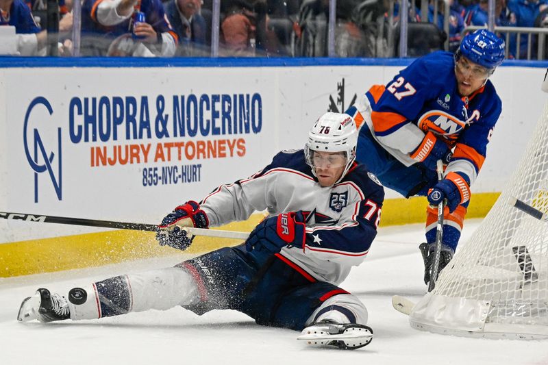 Nov 2, 2025; Elmont, New York, USA; Columbus Blue Jackets defenseman Damon Severson (78) plays the puck from the ice chased byNew York Islanders left wing Anders Lee (27) during the third period at UBS Arena. Mandatory Credit: Dennis Schneidler-Imagn Images
