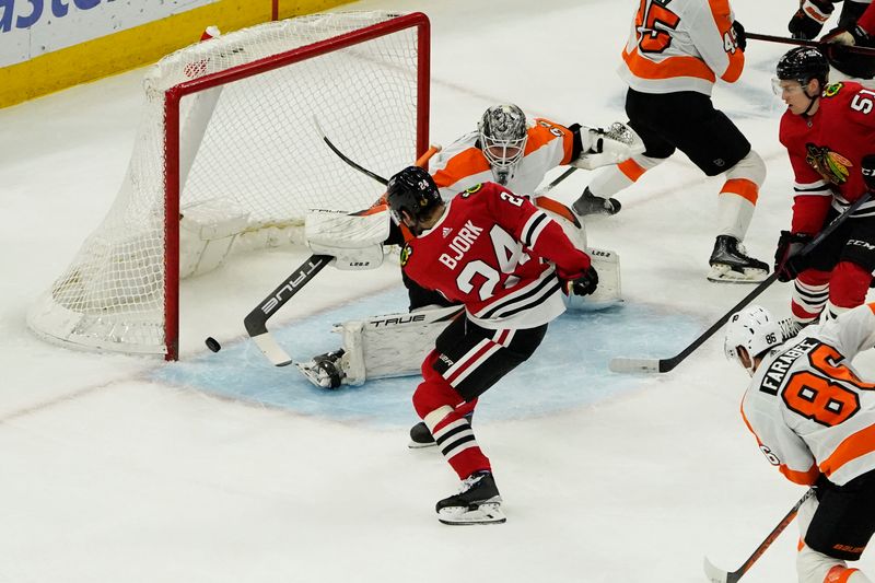 Apr 13, 2023; Chicago, Illinois, USA; Chicago Blackhawks left wing Anders Bjork (24) scores a goal on Philadelphia Flyers goaltender Felix Sandstrom (32) during the first period at United Center. Mandatory Credit: David Banks-USA TODAY Sports