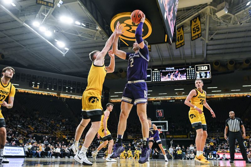 Dec 3, 2024; Iowa City, Iowa, USA; Northwestern Wildcats guard Jalen Leach (1) shoots the ball over Iowa Hawkeyes guard Josh Dix (4) during the first half at Carver-Hawkeye Arena. Mandatory Credit: Jeffrey Becker-Imagn Images