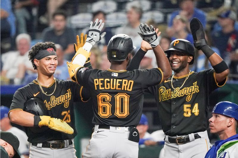 Aug 29, 2023; Kansas City, Missouri, USA; Pittsburgh Pirates shortstop Liover Peguero (60) celebrates with catcher Endy Rodriguez (25) and right fielder Joshua Palacios (54) after scoring against the Kansas City Royals in the ninth inning at Kauffman Stadium. Mandatory Credit: Denny Medley-USA TODAY Sports