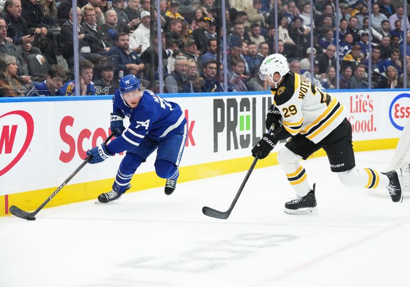 Nov 5, 2024; Toronto, Ontario, CAN; Toronto Maple Leafs center Bobby McMann (74) skates with the puck behind the net as Boston Bruins defenseman Parker Wotherspoon (29) tries to defend during the third period at Scotiabank Arena. Mandatory Credit: Nick Turchiaro-Imagn Imagess