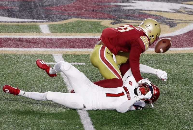 Nov 28, 2020; Chestnut Hill, Massachusetts, USA; Louisville Cardinals wide receiver Tutu Atwell (1) fumbles the ball as he is knocked down by Boston College Eagles defensive back Josh DeBerry (21) during the first half at Alumni Stadium. Mandatory Credit: Winslow Townson-USA TODAY Sports