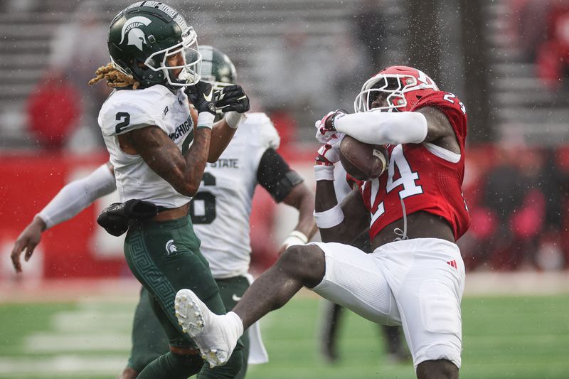 Oct 14, 2023; Piscataway, New Jersey, USA; Rutgers Scarlet Knights defensive back Thomas Amankwaa (24) stripes the ball away from Michigan State Spartans wide receiver Tyrell Henry (2) during a kick off during the second half at SHI Stadium. Mandatory Credit: Vincent Carchietta-USA TODAY Sports