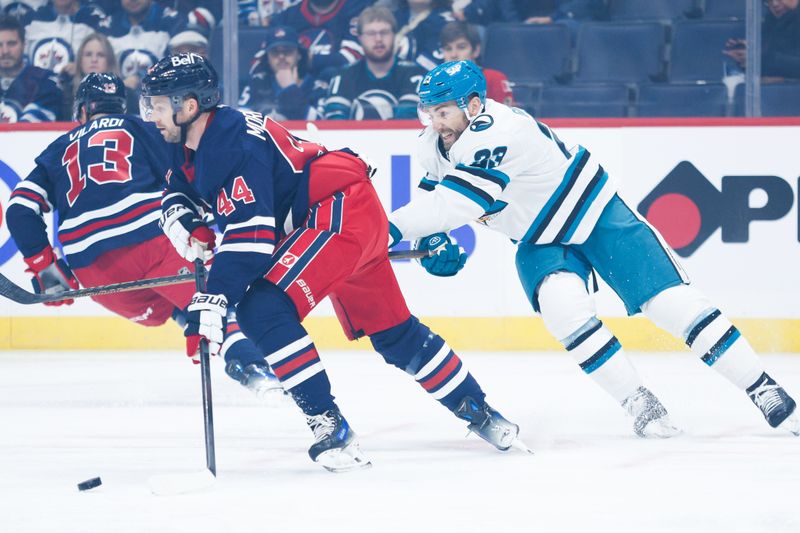 Oct 18, 2024; Winnipeg, Manitoba, CAN;  Winnipeg Jets defenseman Josh Morrissey (44) skates away from San Jose Sharks forward Barclay Goodrow (23) during the first period at Canada Life Centre. Mandatory Credit: Terrence Lee-Imagn Images