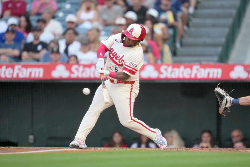 Jul 12, 2024; Anaheim, California, USA; Los Angeles Angels designated hitter Willie Calhoun (5) hits a two-run home run in the first inning against the Seattle Mariners at Angel Stadium. Mandatory Credit: Kirby Lee-USA TODAY Sports