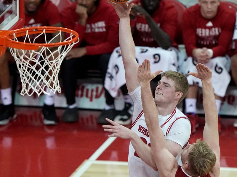 Jan 6, 2024; Madison, Wisconsin, USA; Wisconsin forward Steven Crowl (22) scores on Nebraska forward Rienk Mast (51) during the first half  at Kohl Center. Mandatory Credit: Mark Hoffman-USA TODAY Sports