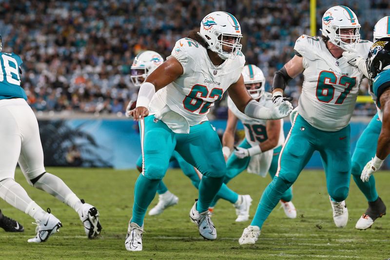 Miami Dolphins center Alama Uluave (62) in action during an NFL pre-season football game against the Jacksonville Jaguars, Saturday, Aug. 26, 2023, in Jacksonville, Fla. The Jaguars defeated the Dolphins 31-18. (AP Photo/Gary McCullough)