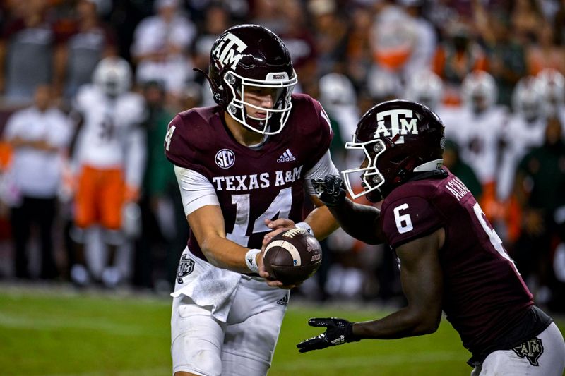 Sep 17, 2022; College Station, Texas, USA; Texas A&M Aggies quarterback Max Johnson (14) hands off to running back Devon Achane (6) during the second half against the Miami Hurricanes at Kyle Field. Mandatory Credit: Jerome Miron-USA TODAY Sports