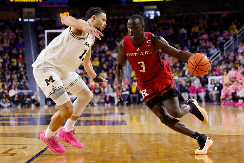 Feb 3, 2024; Ann Arbor, Michigan, USA;  Rutgers Scarlet Knights forward Mawot Mag (3) dribbles on Michigan Wolverines forward Olivier Nkamhoua (13) in the second half at Crisler Center. Mandatory Credit: Rick Osentoski-USA TODAY Sports