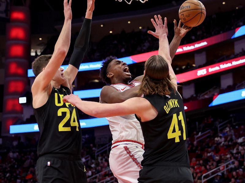 HOUSTON, TEXAS - JANUARY 20: Jae'Sean Tate #8 of the Houston Rockets shoots the ball while defended by Kelly Olynyk #41 of the Utah Jazz and Walker Kessler #24 in the first half at Toyota Center on January 20, 2024 in Houston, Texas.  NOTE TO USER: User expressly acknowledges and agrees that, by downloading and or using this photograph, User is consenting to the terms and conditions of the Getty Images License Agreement. (Photo by Tim Warner/Getty Images)