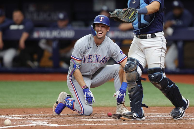 Oct 4, 2023; St. Petersburg, Florida, USA; Texas Rangers left fielder Evan Carter (32) reacts after being hit by a pitch in the eighth inning against the Tampa Bay Rays during game two of the Wildcard series for the 2023 MLB playoffs at Tropicana Field. Mandatory Credit: Nathan Ray Seebeck-USA TODAY Sports