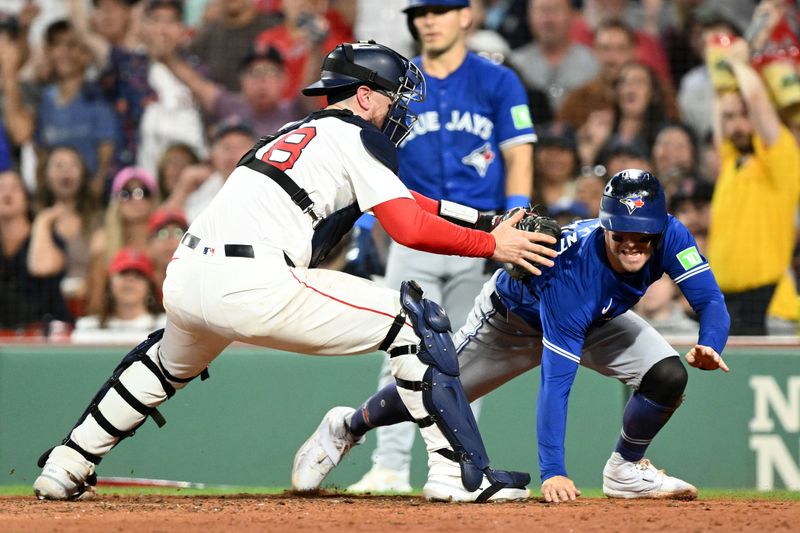 Aug 27, 2024; Boston, Massachusetts, USA; Boston Red Sox catcher Danny Jansen (28) tags out Toronto Blue Jays third baseman Ernie Clement (28) at home during the fourth inning at Fenway Park. Mandatory Credit: Brian Fluharty-USA TODAY Sports