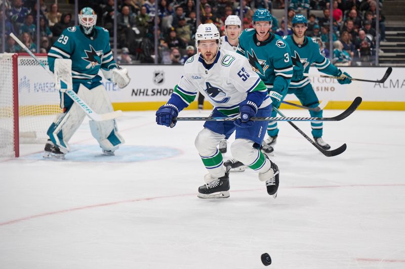 Nov 2, 2024; San Jose, California, USA; Vancouver Canucks center Teddy Blueger (53) plays the puck against San Jose Sharks defenseman Henry Thrun (3) during the first period at SAP Center at San Jose. Mandatory Credit: Robert Edwards-Imagn Images