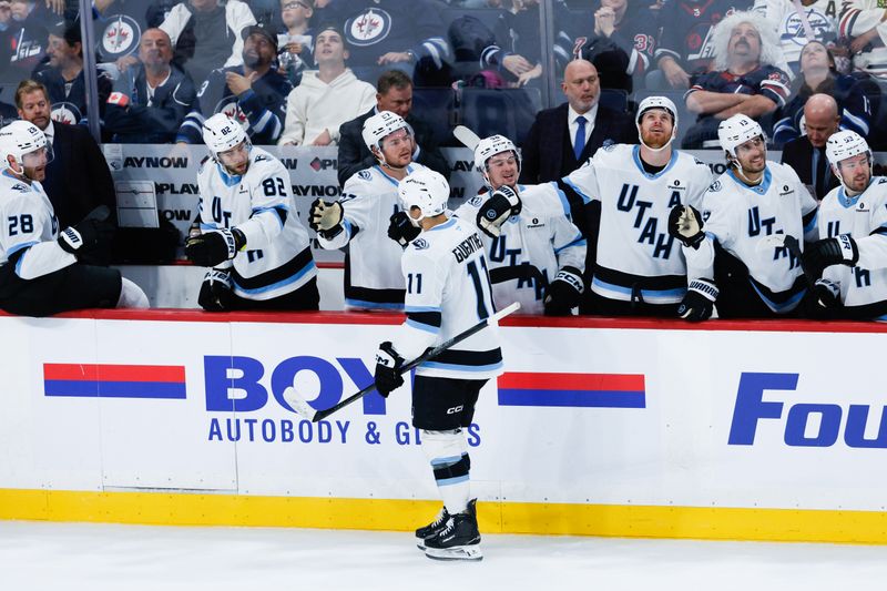 Oct 26, 2025; Winnipeg, Manitoba, CAN; Utah Mammoth forward forward Dylan Guenther (11) is congratulated by his team mates on his goal against the Winnipeg Jets during the third period at Canada Life Centre. Mandatory Credit: Terrence Lee-Imagn Images