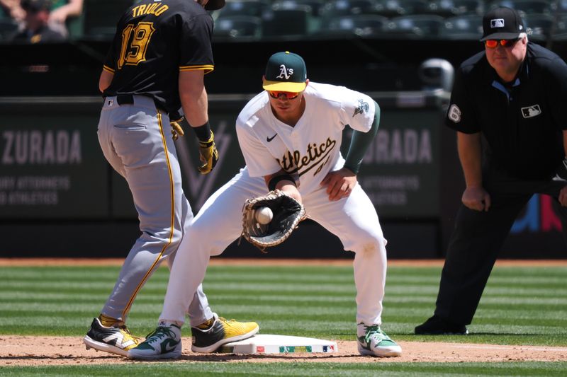 May 1, 2024; Oakland, California, USA; Oakland Athletics first baseman Ryan Noda (49) catches the ball as Pittsburgh Pirates second baseman Jared Triolo (19) returns safely to first base during the seventh inning at Oakland-Alameda County Coliseum. Mandatory Credit: Kelley L Cox-USA TODAY Sports