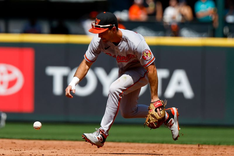 Aug 13, 2023; Seattle, Washington, USA; Baltimore Orioles second baseman Adam Frazier (12) fields a single against the Seattle Mariners during the second inning at T-Mobile Park. Mandatory Credit: Joe Nicholson-USA TODAY Sports