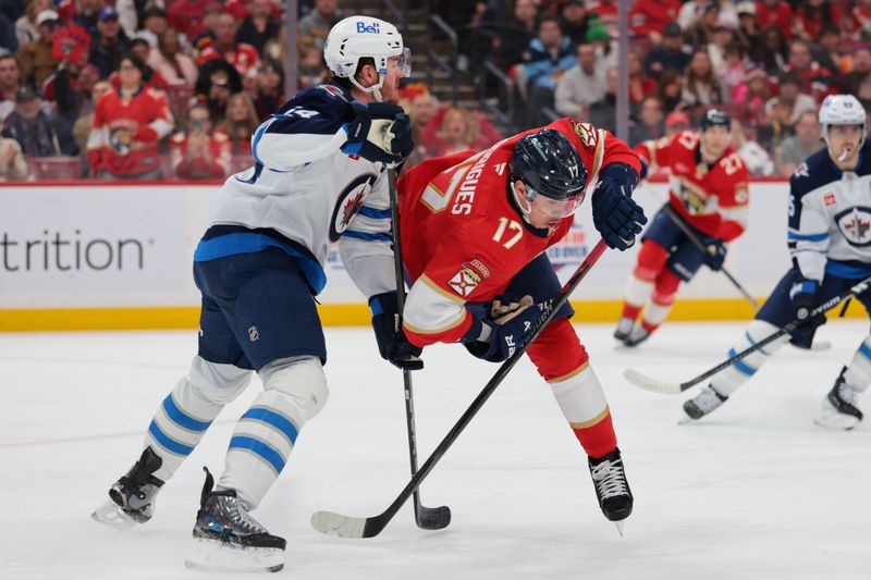 Jan 31, 2026; Sunrise, Florida, USA; Florida Panthers center Evan Rodrigues (17) collides with Winnipeg Jets defenseman Dylan Samberg (54) during the second period at Amerant Bank Arena. Mandatory Credit: Sam Navarro-Imagn Images