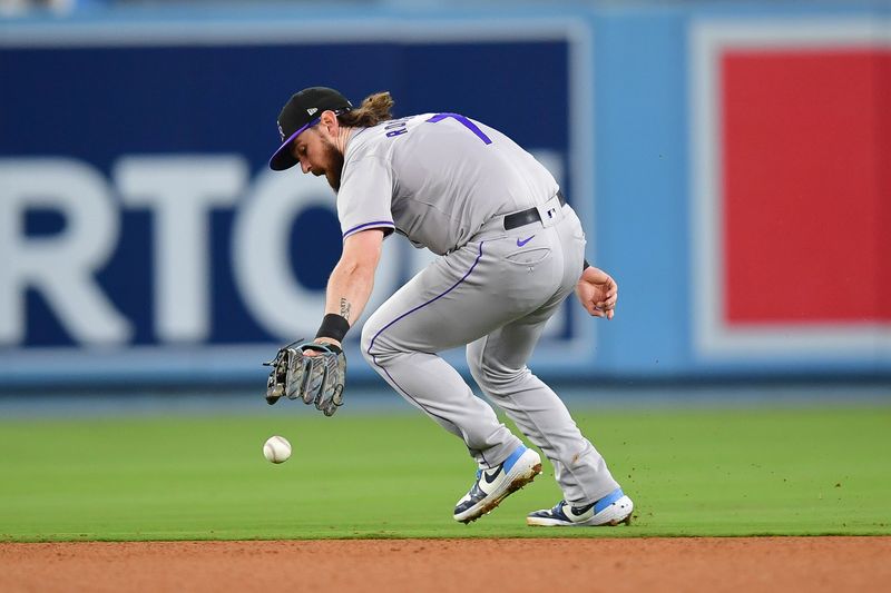 May 31, 2024; Los Angeles, California, USA; Colorado Rockies second baseman Brendan Rodgers (7) is unable to field the single of Los Angeles Dodgers second baseman Gavin Lux (9) during the fifth inning at Dodger Stadium. Mandatory Credit: Gary A. Vasquez-USA TODAY Sports