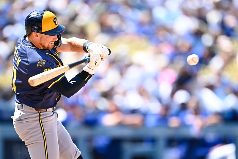 Jul 20, 2025; Los Angeles, California, USA; Milwaukee Brewers third baseman Caleb Durbin (21) hits the ball into play against the Los Angeles Dodgers during the sixth inning at Dodger Stadium. Mandatory Credit: Jonathan Hui-Imagn Images