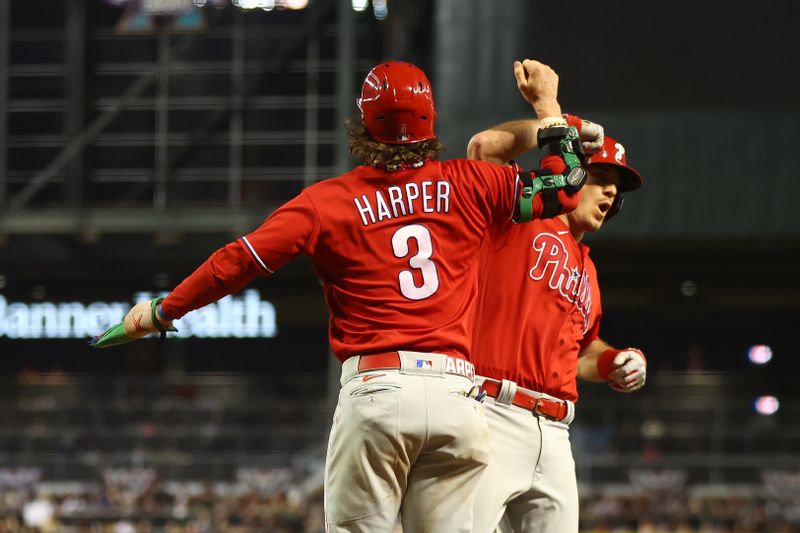 Oct 21, 2023; Phoenix, Arizona, USA; Philadelphia Phillies catcher J.T. Realmuto (10) reacts with Philadelphia Phillies designated hitter Bryce Harper (3) after hitting a two run home run against the Arizona Diamondbacks in the eighth inning during game five of the NLCS for the 2023 MLB playoffs at Chase Field. Mandatory Credit: Mark J. Rebilas-USA TODAY Sports