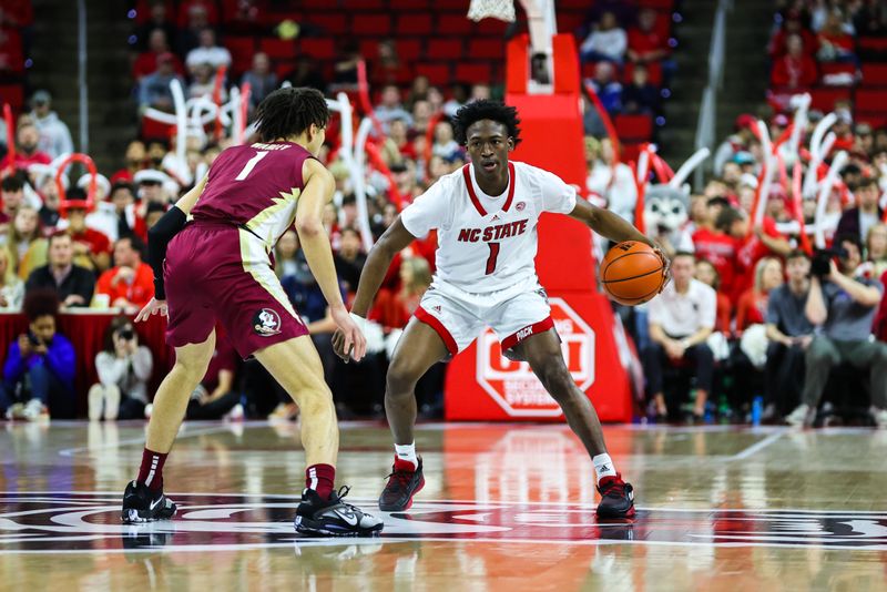 Feb 1, 2023; Raleigh, North Carolina, USA;  North Carolina State Wolfpack guard Jarkel Joiner (1) controls the ball against Florida State Seminoles guard Jalen Warley (1) guards him during the first half at PNC Arena.  Mandatory Credit: Jaylynn Nash-USA TODAY Sports