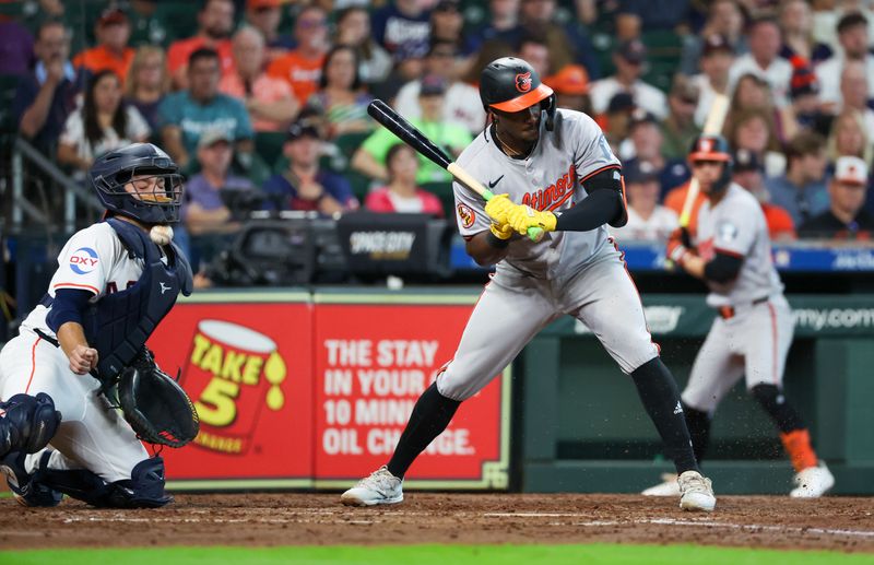 Jun 23, 2024; Houston, Texas, USA; Houston Astros catcher Cesar Salazar (18) gets hit in the neck with the ball while Baltimore Orioles shortstop Jorge Mateo (3) bats in the fourth inning at Minute Maid Park. Mandatory Credit: Thomas Shea-USA TODAY Sports