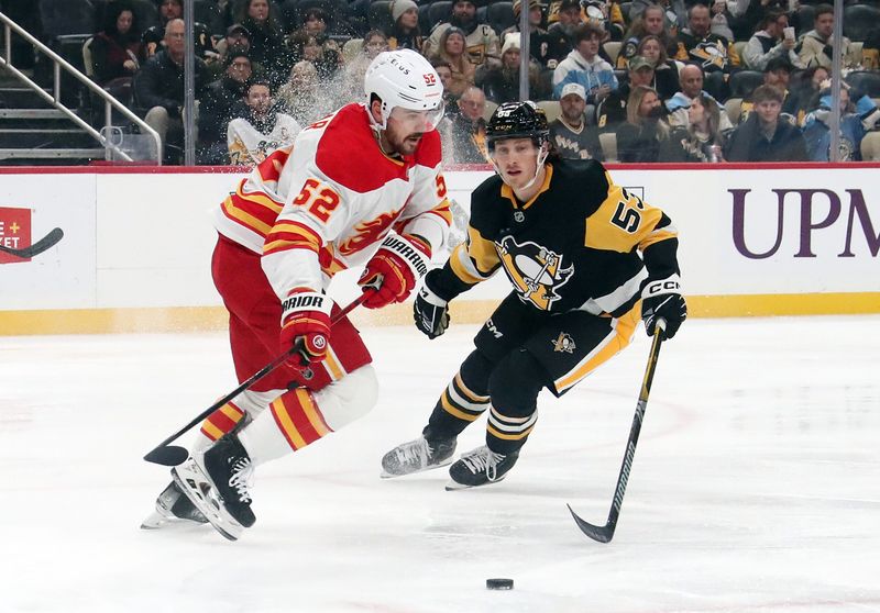 Nov 30, 2024; Pittsburgh, Pennsylvania, USA;  Calgary Flames defenseman MacKenzie Weegar (52) moves the puck against Pittsburgh Penguins center Philip Tomasino (53) during the first period at PPG Paints Arena. Mandatory Credit: Charles LeClaire-Imagn Images