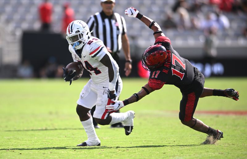 Sep 3, 2022; San Diego, California, USA; Arizona Wildcats running back Jonah Coleman (24) runs the ball past San Diego State Aztecs cornerback Noah Avinger (17) during the second half at Snapdragon Stadium. Mandatory Credit: Orlando Ramirez-USA TODAY Sports