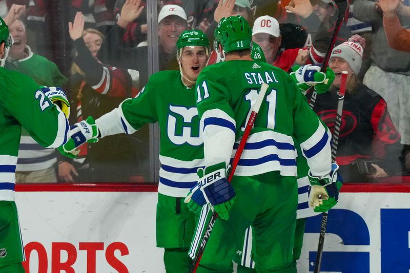 Mar 26, 2023; Raleigh, North Carolina, USA;  Carolina Hurricanes defenseman Brady Skjei (76) is congratulated by center Jordan Staal (11) after his goal against the Boston Bruins during the third period at PNC Arena. Mandatory Credit: James Guillory-USA TODAY Sports