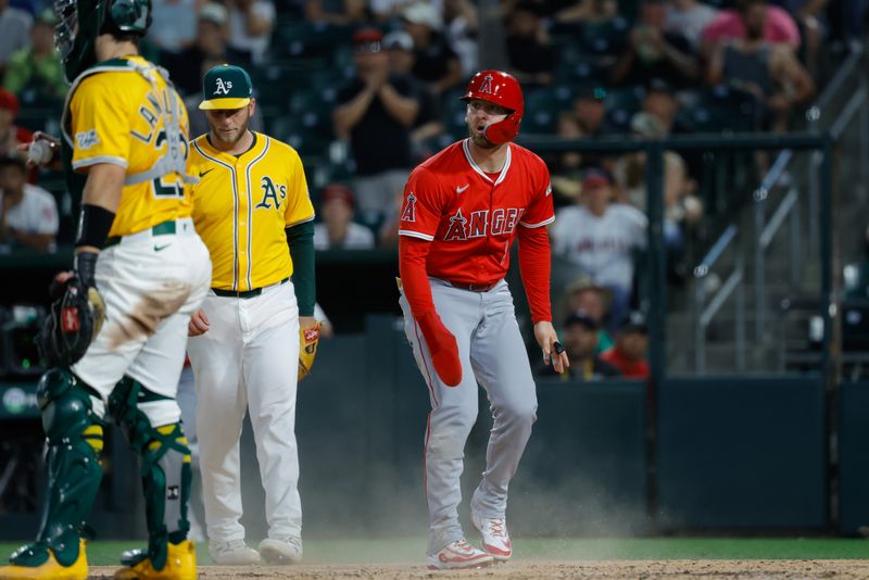 May 20, 2025; West Sacramento, California, USA; Los Angeles Angels left fielder Taylor Ward (3) avoids the tag by Athletics catcher Shea Langeliers (23) to score a run during the fifth inning against the Athletics at Sutter Health Park. Mandatory Credit: Sergio Estrada-Imagn Images