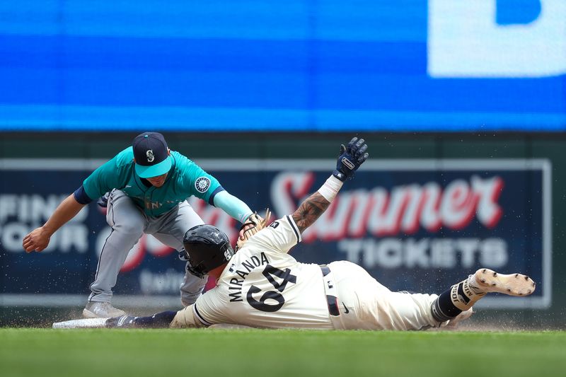 May 9, 2024; Minneapolis, Minnesota, USA; Minnesota Twins Jose Miranda (64) slides into second base as Seattle Mariners shortstop Leo Rivas (76) attempts a tag during the seventh inning at Target Field. Mandatory Credit: Matt Krohn-USA TODAY Sports