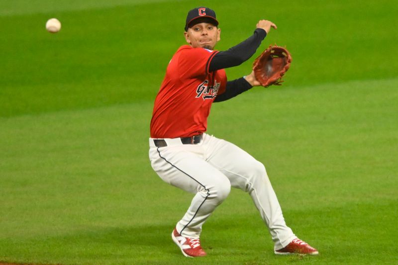 Sep 25, 2024; Cleveland, Ohio, USA; Cleveland Guardians second baseman Andres Gimenez (0) throws to first base in the seventh inning against the Cincinnati Reds at Progressive Field. Gimenez was charged with a throwing error on the play. Mandatory Credit: David Richard-Imagn Images