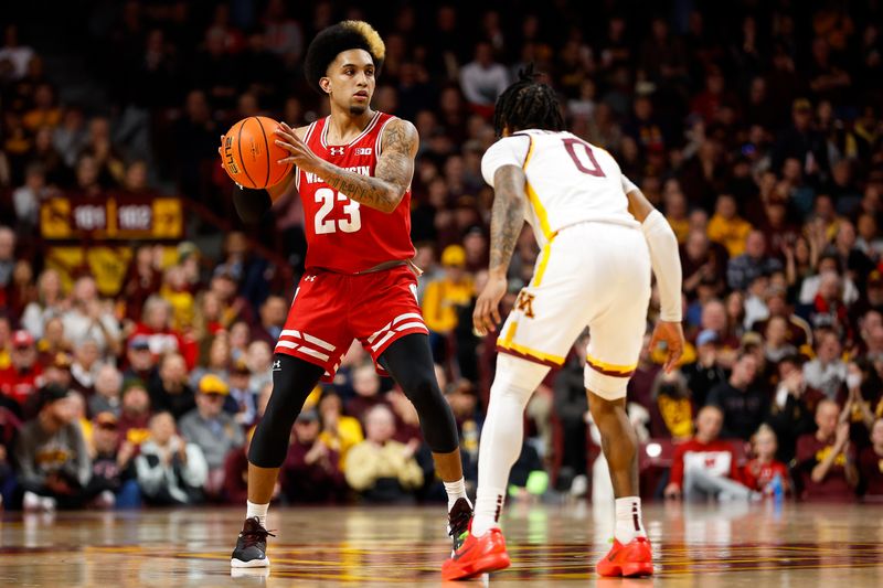 Jan 23, 2024; Minneapolis, Minnesota, USA; Wisconsin Badgers guard Chucky Hepburn (23) controls the ball as Minnesota Golden Gophers guard Elijah Hawkins (0) defends during the second half at Williams Arena. Mandatory Credit: Matt Krohn-USA TODAY Sports