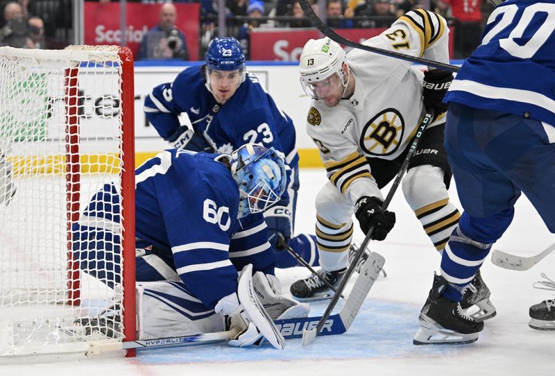 May 2, 2024; Toronto, Ontario, CAN;   Toronto Maple Leafs goalie Joseph Woll (60) covers the puck as Boston Bruins forward Charlie Coyle (13) tries to poke it loose in the second period in game six of the first round of the 2024 Stanley Cup Playoffs at Scotiabank Arena. Mandatory Credit: Dan Hamilton-USA TODAY Sports