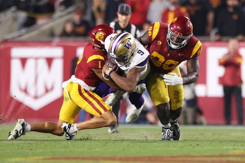 Nov 4, 2023; Los Angeles, California, USA; USC Trojans cornerback Domani Jackson (1) and defensive lineman Bear Alexander (90) tackle Washington Huskies quarterback Michael Penix Jr. (9) during the third quarter at United Airlines Field at Los Angeles Memorial Coliseum. Mandatory Credit: Jessica Alcheh-USA TODAY Sports