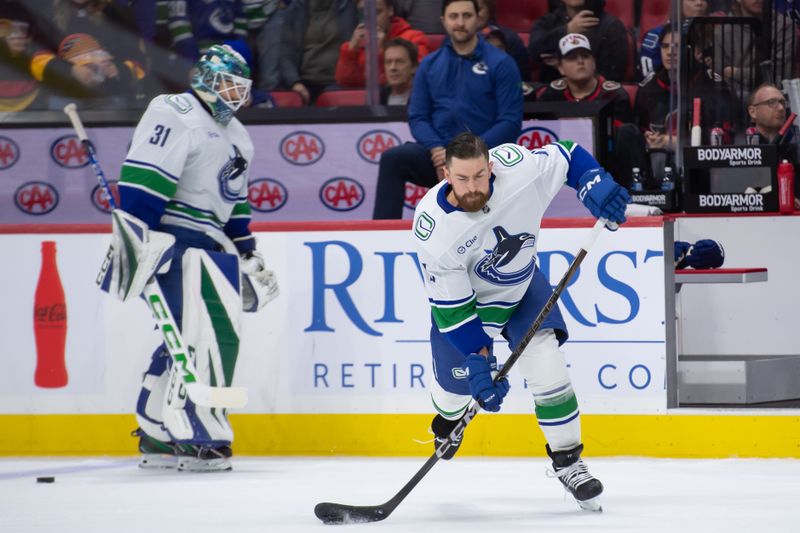 Nov 23, 2024; Ottawa, Ontario, CAN; Vancouver Canucks defenseman Filip Hronek (17) shoots  the puck during warmup prior to game against the Ottawa Senators at the Canadian Tire Centre. Mandatory Credit: Marc DesRosiers-Imagn Images