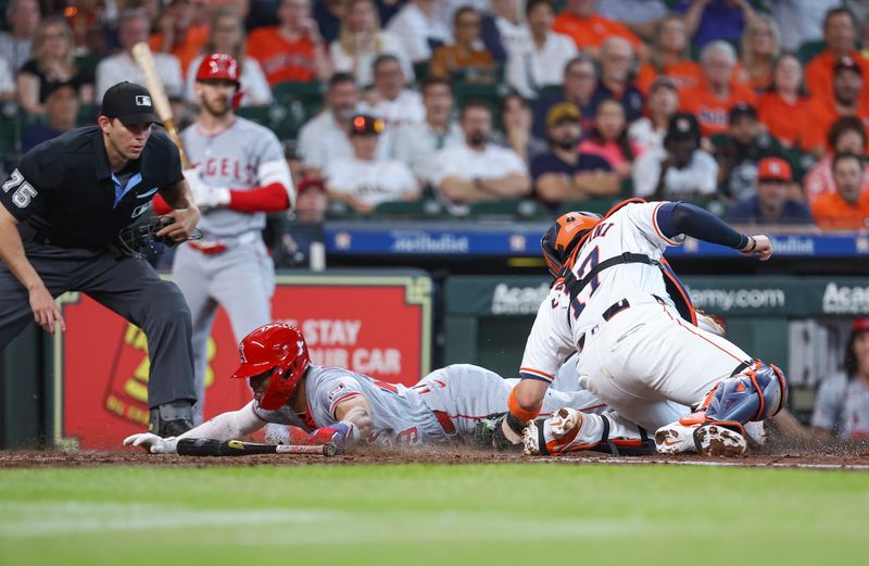 May 22, 2024; Houston, Texas, USA; Los Angeles Angels second baseman Kyren Paris (19) is called out on a play at the plate as Houston Astros catcher Victor Caratini (17) appies a tag at Minute Maid Park. Mandatory Credit: Troy Taormina-USA TODAY Sports