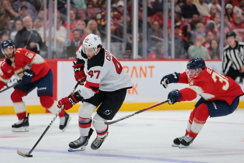 Nov 20, 2025; Sunrise, Florida, USA; New Jersey Devils left wing Paul Cotter (47) moves the puck against Florida Panthers right wing Jack Devine (38) during the third period at Amerant Bank Arena. Mandatory Credit: Sam Navarro-Imagn Images