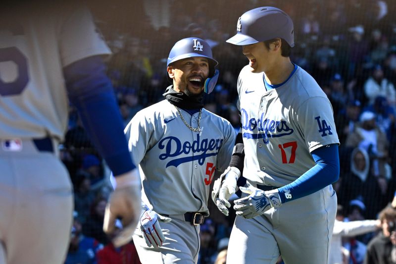 Apr 5, 2024; Chicago, Illinois, USA;  Los Angeles Dodgers two-way player Shohei Ohtani (17) celebrates with shortstop Mookie Betts (50) after hitting a two-run home run  against the Chicago Cubs that scored them both during the fifth inning at Wrigley Field. Mandatory Credit: Matt Marton-USA TODAY Sports