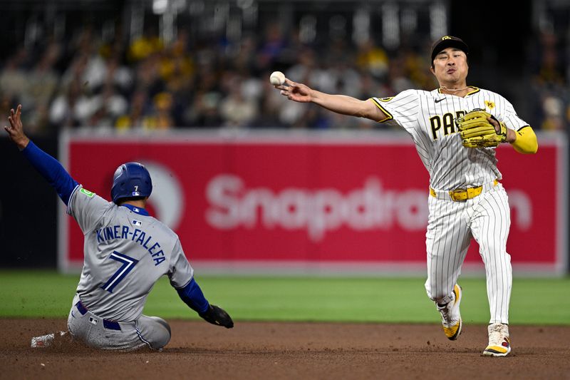 Apr 20, 2024; San Diego, California, USA; San Diego Padres shortstop Ha-Seong Kim (right) throws to first base after forcing out Toronto Blue Jays third baseman Isiah Kiner-Falefa (7) at second base to complete a double play during the seventh inning at Petco Park. Mandatory Credit: Orlando Ramirez-USA TODAY Sports