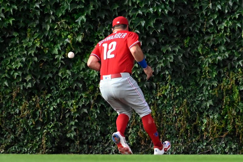 Jun 29, 2023; Chicago, Illinois, USA;  Philadelphia Phillies left fielder Kyle Schwarber (12) drops a fly ball hit by Chicago Cubs center fielder Mike Tauchman (40) during the fifth inning at Wrigley Field. Mandatory Credit: Matt Marton-USA TODAY Sports