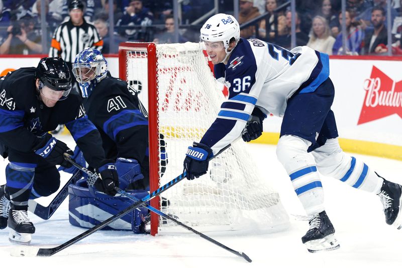 Oct 28, 2024; Winnipeg, Manitoba, CAN; Toronto Maple Leafs defenseman Morgan Reilly (44) defends Winnipeg Jets forward Morgan Barron (36) in front of Toronto Maple Leafs goalie Anthony Stolarz (41) during the second period at Canada Life Centre. Mandatory Credit: Terrence Lee-Imagn Images