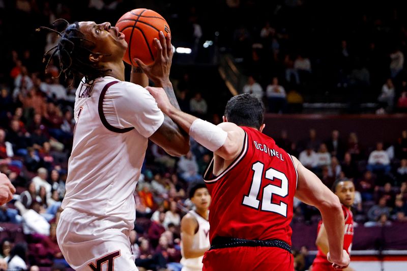 Jan 15, 2025; Blacksburg, Virginia, USA; Virginia Tech Hokies forward Tobi Lawal (1) is fouled by North Carolina State Wolfpack guard Michael O'Connell (12) during the first half at Cassell Coliseum. Mandatory Credit: Peter Casey-Imagn Images