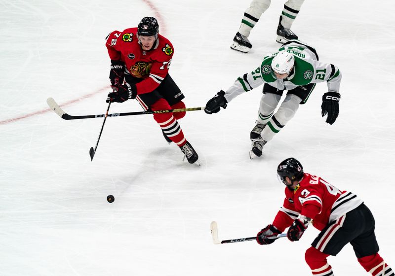 Apr 6, 2024; Chicago, Illinois, USA; Chicago Blackhawks defenseman Alex Vlasic (72) keeps the puck away from Dallas Stars left winger Jason Robertson (21) during the second period at United Center. Mandatory Credit: Seeger Gray-USA TODAY Sports